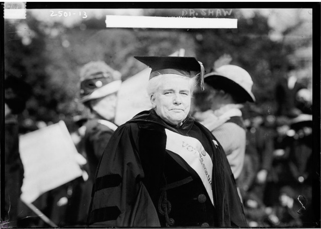 This 1913 photograph features Dr. Anna Howard Shaw, a key leader in the women's suffrage movement. Shaw, a Methodist minister, is shown with an American flag pin, highlighting her advocacy for women's rights and suffrage. She was an influential figure in the fight for women's voting rights in the United States.